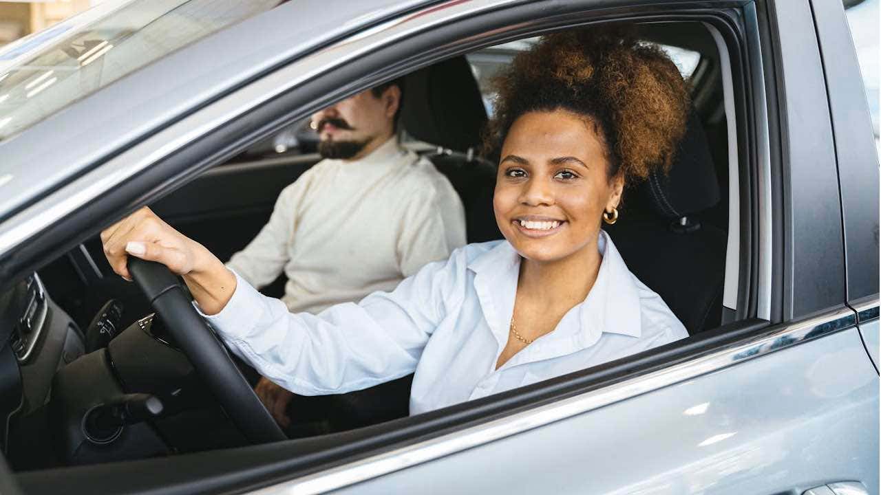 1-The-double-edged-sword-of-insurance-tracking-programs-smiling-woman-in-car.jpg