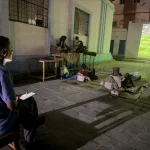 Adel-Mohsen-watches-the-opening-match-of-the-World-Cup-on-a-giant-public-screen-in-Mukalla-while-tak.webp